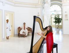 Rimske Terme Hotel Rimski dvor Eine Harfespielerin und zwei Gäste im Bademantel im historischen Teil des Wellnessbereiches im Rimske Terme Hotel Rimski dvor