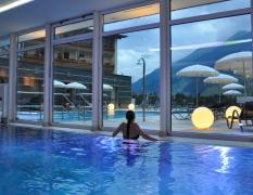 Alpinhotel Jesacherhof Eine Dame im Innenpool mit Blick auf den Aussenpool im Alpinhotel Jesacherhof bei Abendstimmung