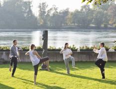 Mehrere Gäste beim TaiChi direkt am Wasser im Gesundheitshotel Gugerbauer