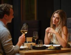 Impulshotel Freigold - Paar am Abend beim Abendessen mit einem Glas Wein
