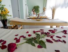 Ein Doppelbett mit roten Rosenblättern dekoriert im Grand Hotel Astoria