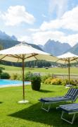Hotel Drei Zinnen Garten des Hotels Drei Zinnen mit Schwimmbad und Liegen
