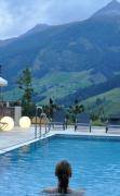 Alpinhotel Jesacherhof Eine Dame im Aussenpool mit Ruheliegen im Alpinhotel Jesacherhof