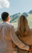 Paar auf dem Balkon des Hotels Alpine Palace mit Blick in den Ort